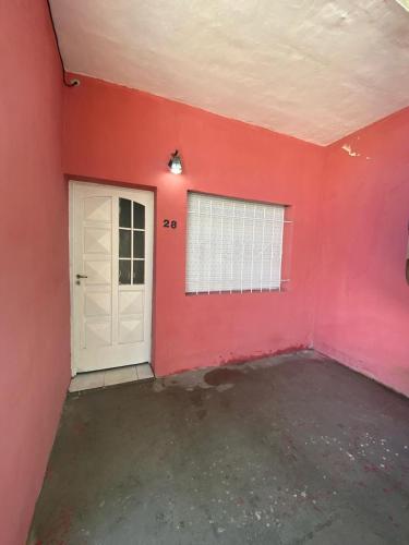 um quarto com uma porta branca e uma parede vermelha em Casa para 4 personas, DOS HABITACIONES, excelente ubicación a 30 metros del casino, y a 50 metros de la parte principal de costanera , equipada entera, wifi em Gualeguaychú