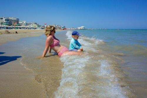 a woman and a child playing in the water at the beach at Tenuta Tredici Ulivi in Senigallia