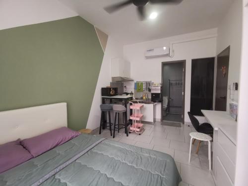 1 dormitorio con 1 cama y cocina con sillas en Studio@Astetica, en Seri Kembangan