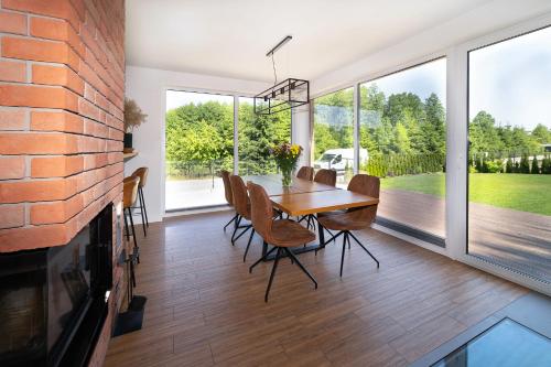 a dining room with a table and chairs at Forest House - Domy Mazur in Regiel