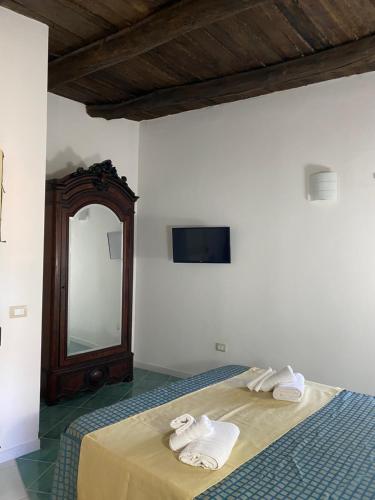 a bedroom with a bed with towels and a mirror at La Locanda del Curato Rooms in Lentiscosa