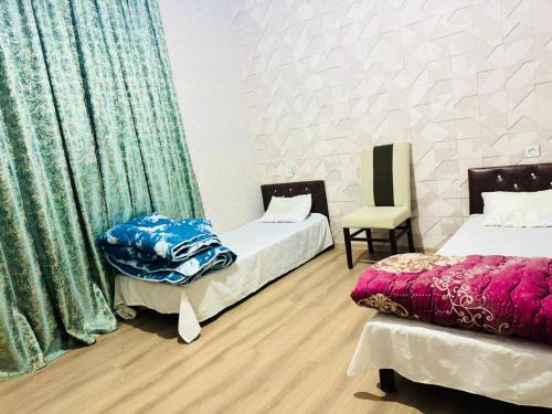 a room with two beds and a chair in it at Key Explore Hostel Hotel in Baku