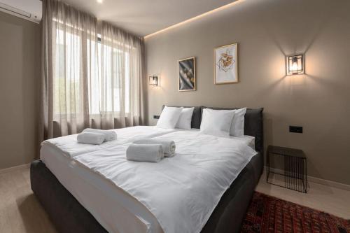 um quarto com uma grande cama branca com toalhas em Villa Costa em Funtana