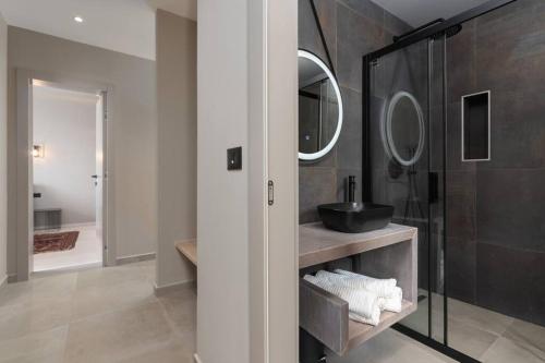 uma casa de banho com um lavatório e um chuveiro com espelhos em Villa Costa em Funtana