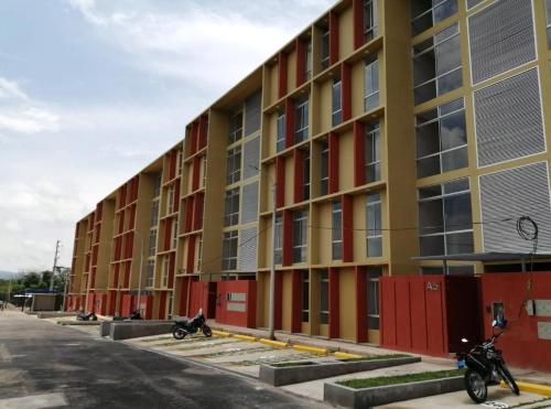 a row of apartment buildings with motorcycles parked outside at Confortable Departamento Nuevo in Tarapoto