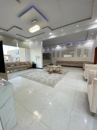una gran sala de estar con sofás y una mesa. en شاليهات ملك, en Rafha
