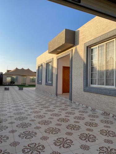 una casa con suelo de baldosa delante de ella en شاليهات ملك, en Rafha