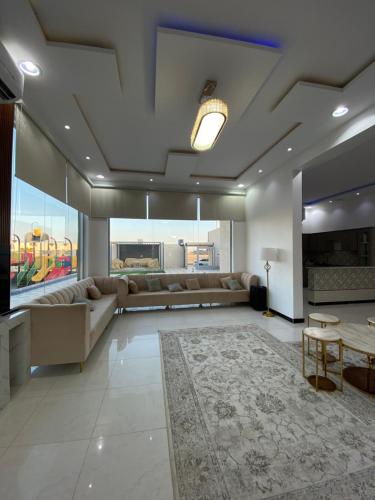 sala de estar con sofá y mesa en شاليهات ملك, en Rafha
