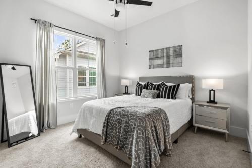 a white bedroom with a bed and a large window at Lux Living - East Downtown Rooftop with King Suite & Private Chef in Houston