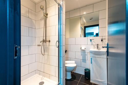 een badkamer met een douche, een toilet en een wastafel bij Russel Street in Nottingham