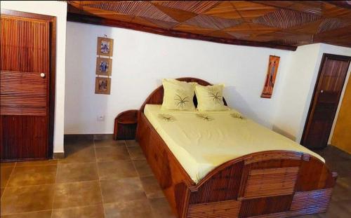 a bedroom with a wooden bed in a room at OROKA EDEN in Ambondrona