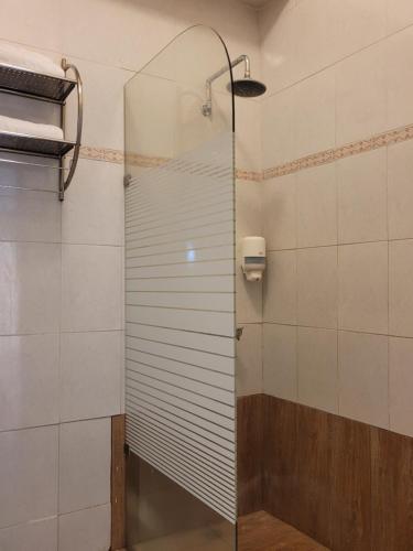 y baño con ducha y puerta de cristal. en Aparta Hotel Drake Bolivar, en Santo Domingo