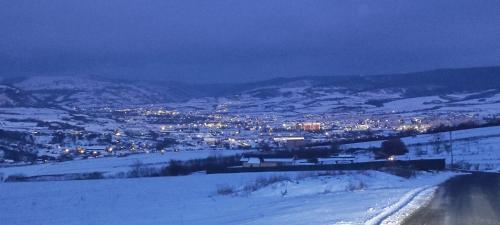 a view of a city in the snow at night at Sunset Hills Transylvania in Odorheiu Secuiesc