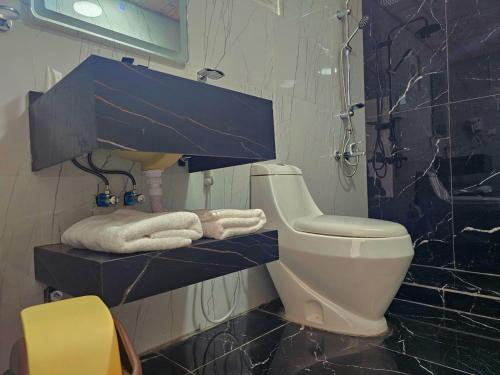 e bagno con servizi igienici, doccia e asciugamani. di Wadi rum anwar luxury camp a Wadi Rum