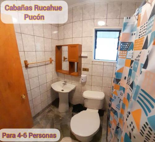 y baño con aseo y lavamanos. en Cabañas Rucahue en Pucón