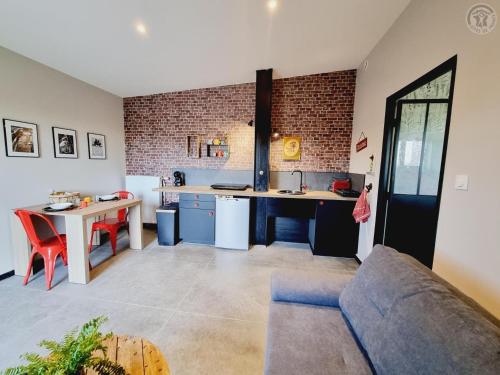 une cuisine et un salon avec un canapé et une table dans l'établissement Le Kot'je - Les gites de La Petite Ferme Flamande, à Rexpoëde