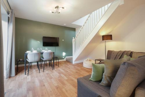 a living room with a couch and a table with chairs at Tapton View - Modern Stay Near Chesterfield Town Center, Train Station & the Peak District in Brimington