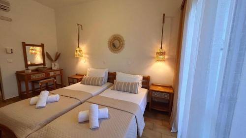 two beds in a hotel room with towels on them at ANGELOS STUDIOS 1-2 Ground Floor in Faliraki