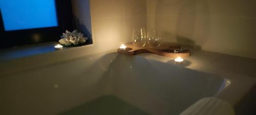 a bathroom with a tub with candles and a window at Sunset Hills Transylvania in Odorheiu Secuiesc