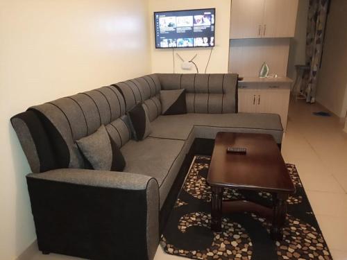 a living room with a couch and a table at Roma Stays - Spacious 1BR Sunset Paradise Apartment with Swimming Pool in Shanzu in Mombasa