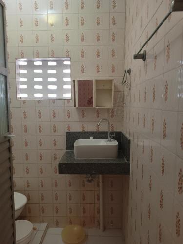 baño con lavabo y aseo y ventana en Casa para carnaval, en Salvador