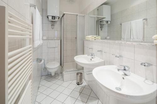 ein weißes Bad mit einem Waschbecken und einem WC in der Unterkunft Haus Tiemann Wohnung 2 in Norderney