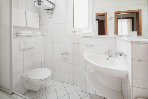 a white bathroom with a toilet and a sink at Haus Tiemann Wohnung 7 in Norderney