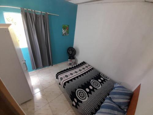 a bedroom with a bed with a black and white pillow at Kitnet Mobiliada Itaboraí in Itaboraí