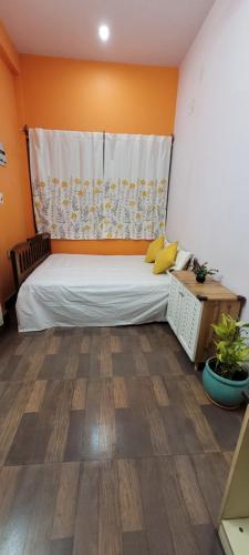 a bedroom with a large bed with orange walls at Feel the Bong vibes in a villa nearest to airport. in Kolkata