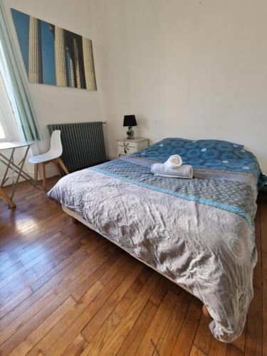 een slaapkamer met een bed en een houten vloer bij Le Klein, Studio au calme au centre de Besançon in Besançon