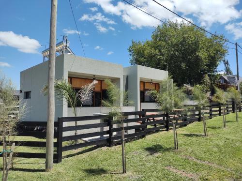 una casa con una valla delante de ella en Cabañas Posta Litoral en Colón