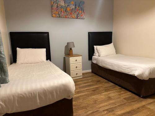 two beds sitting next to each other in a room at Spanish Point Holiday Homes in Spanish Point