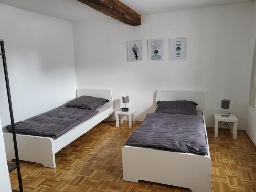 Habitación con 2 camas, paredes blancas y suelo de madera. en Zum Edelhof 24, en Homberg Ohm
