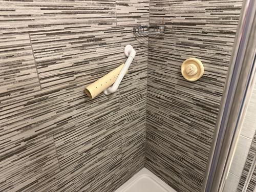 a shower with a wooden bat on the wall at Spanish Point Holiday Homes in Spanish Point