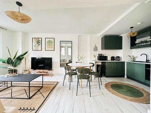 cocina y sala de estar con mesa y sillas en Maison Médiévale, en Laon