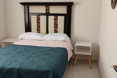 a bedroom with a bed with a wooden head board at Dpto en Altozano 34 in Morelia