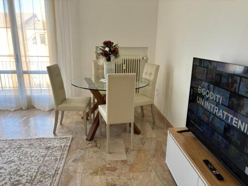 a dining room with a table and chairs and a television at Sferica in Campalto