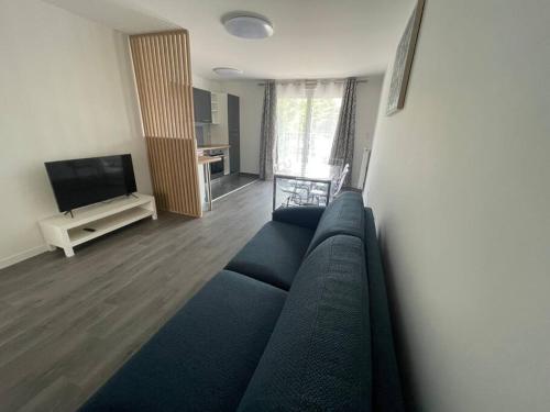 un soggiorno con divano blu e TV di Appartement résidentiel Longjumeau a Longjumeau