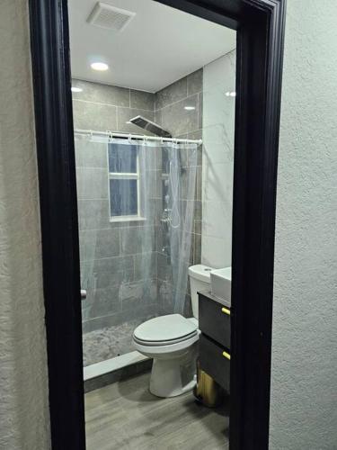 uma casa de banho com um WC branco e um chuveiro em Quiet House Near the Hard R Casino and FLL Airport em Fort Lauderdale