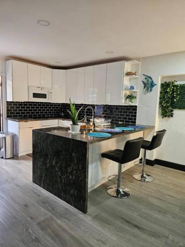 a kitchen with a counter and two bar stools at Quiet House Near the Hard R Casino and FLL Airport in Fort Lauderdale