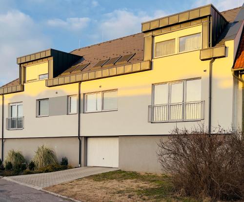 een geel en wit huis met een bruin dak bij Apartment K21 - Győr in Győr