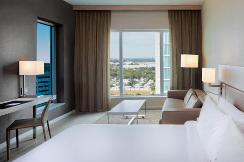 a hotel room with a large bed and a desk at AC Hotel by Marriott Fort Lauderdale Airport in Dania Beach