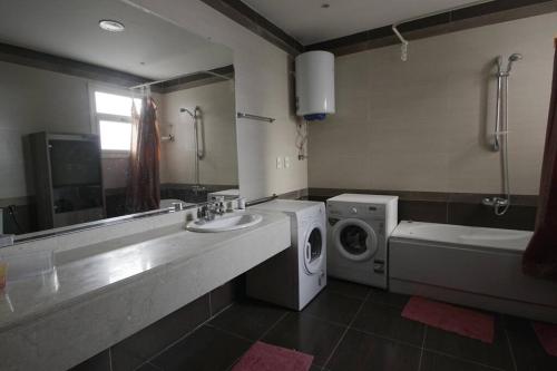 La salle de bains est pourvue d'un lave-linge et d'un sèche-linge. dans l'établissement Zamalek Retreat: Premium Stay with Nile View, au Caire