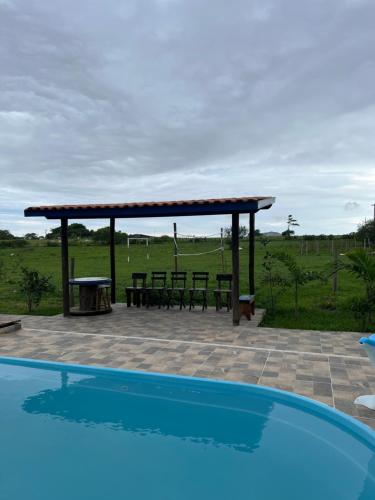 a patio with a picnic table and a pavilion at Casa de campo! Lugar de paz! Próxima as praias não oferecemos roupa de cama e banho in São Pedro da Aldeia