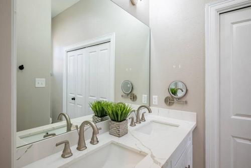 ein Badezimmer mit zwei Waschbecken und einem großen Spiegel in der Unterkunft Pet OK, 10 min to Alphaland, Home Gym, Gated in Houston