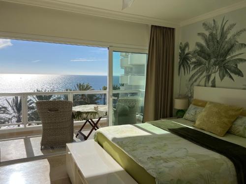 a bedroom with a bed and a view of the ocean at Las Palmas 1 in Marbella