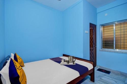 a blue room with a bed and a window at Hotel O Singh Guest House in Kolkata