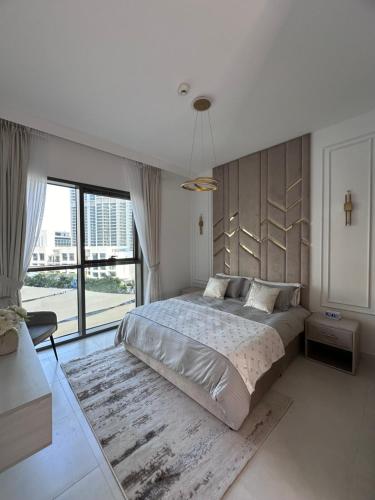 sypialnia z dużym łóżkiem i dużym oknem w obiekcie Creek Harbour retreat: Luxurious 2-BR apartment w Dubaju