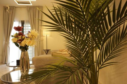 a living room with a vase of flowers on a table at Amber Glow 2BR Apartment Al Raha in Abu Dhabi