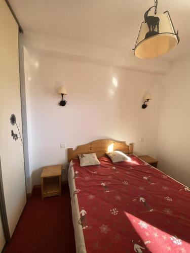 une chambre avec un grand lit avec une couverture rouge dans l'établissement Résidence Terrasses De La Bergerie - 2 pièces cabine 6 personnes MAE-2034, à Orcières